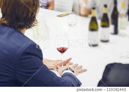 Sommelier looking at holding red wine glass, analysis it color, scrutiny taste and tartness of alcoholic drink, faceless pov shot. Man takes part in lecture on production and history of wine origin. Sommelier looking at holding red wine glass, analysis it color, scrutiny taste and tartness of alcoholic drink, faceless pov shot. Man takes part in lecture on production and history of wine origin. 133192443