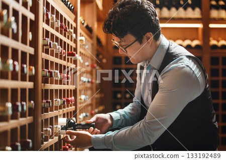 Expert Sommelier Selects Prestigious Vintage Wine From Wooden Cellar Rack Expert Sommelier Selects Prestigious Vintage Wine From Wooden Cellar Rack 133192489