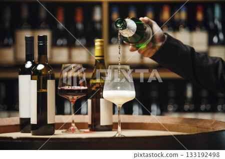 Unrecognizable Professional Sommelier Pouring Sparkling Wine in Wine Cellar Unrecognizable Professional Sommelier Pouring Sparkling Wine in Wine Cellar 133192498