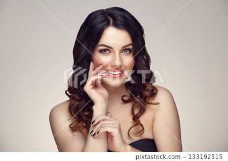 Beauty caucasian female portrait of beautiful brunette woman with clean healthy skin and curly hairs on a gray gradient background. 133192515