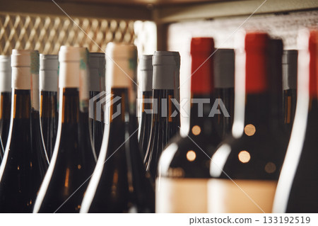 Assorted Wine Bottles Lined Up on Shelf in Cozy Wine Shop Assorted Wine Bottles Lined Up on Shelf in Cozy Wine Shop 133192519