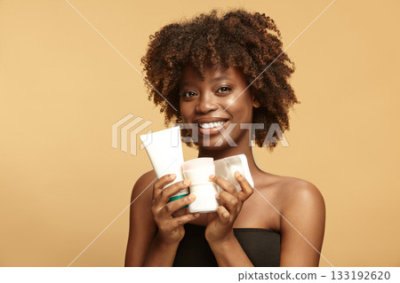 Beautiful girl shows plastic tube, round, square jars mockups. 133192620