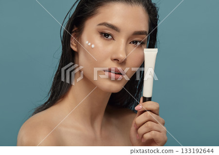 Well groomed woman holds small white cosmetic tube mockup. Well groomed woman holds small white cosmetic tube mockup. 133192644