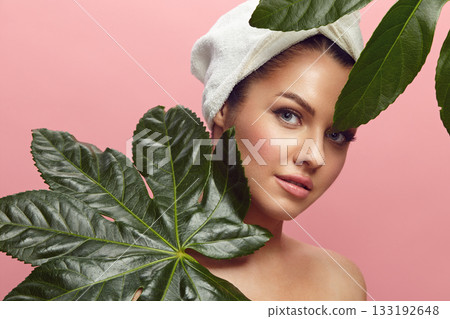 woman in a head towel with tropical leaves on pink isolated background woman in a head towel with tropical leaves on pink isolated background 133192648