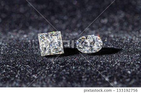 Two diamond shaped gems are on a black surface Two diamond shaped gems are on a black surface 133192756