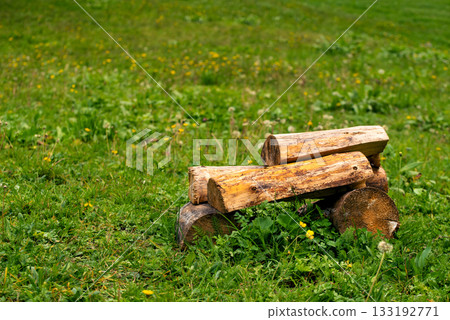 A pile of wood is sitting on the grass in a field A pile of wood is sitting on the grass in a field 133192771
