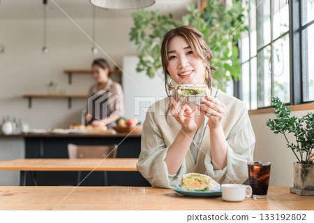 亞洲女性在咖啡館吃三明治當午餐/早午餐/早餐 133192802