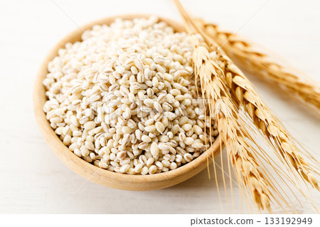 Closeup of barley grains in wooden cup. Closeup of barley grains in wooden cup. 133192949
