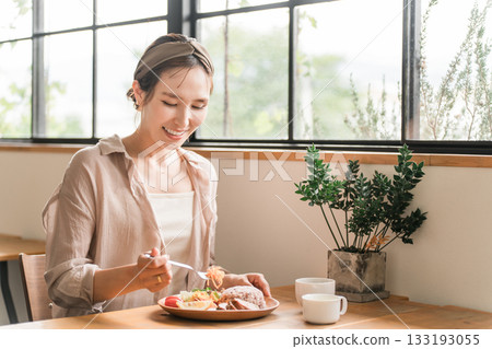 Young Asian woman eating a one-plate lunch at a cafe, restaurant, or dining room 133193055