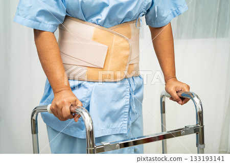 Asian senior pain back wearing elastic support belt with walker. Asian senior pain back wearing elastic support belt with walker. 133193141