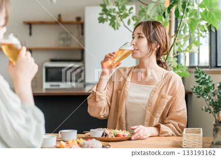 年輕的亞洲女性在咖啡館或家中舉行女孩聚會（白天喝酒、喝啤酒、碰杯、放鬆） 133193162