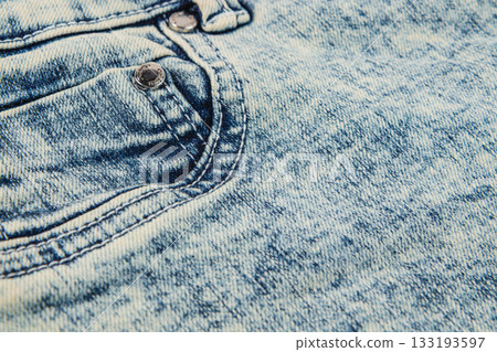 Close-up of faded denim fabric with pockets and stitches in natural light Close-up of faded denim fabric with pockets and stitches in natural light 133193597