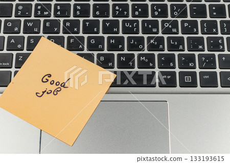 Sticky note with good job message on laptop keyboard during work hours Sticky note with good job message on laptop keyboard during work hours 133193615