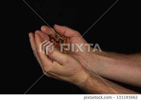 Hands holding prayer beads in a serene setting for meditation practice Hands holding prayer beads in a serene setting for meditation practice 133193662