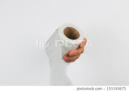 Holding a roll of paper towel in a clean, bright setting 133193675