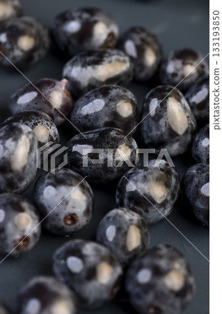 a beautiful ripe grape, torn from a branch, lying on a bowl, covered with drops of water, wet fruits of pure blue grapes on a blue bowl during cooking a beautiful ripe grape, torn from a branch, lying on a bowl, covered with drops of water, wet fruits of pure blue grapes on a blue bowl during cooking 133193850