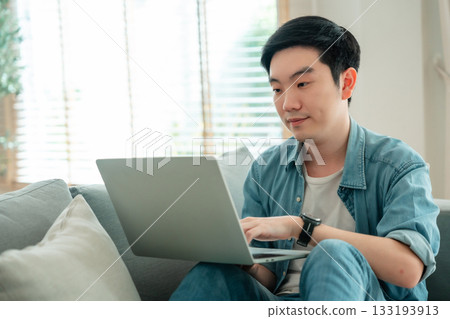 Young Asian man relaxing on comfortable couch Young Asian man relaxing on comfortable couch 133193913