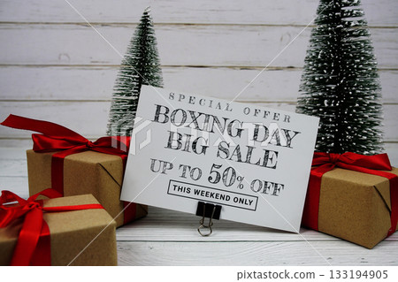 Festive display with small decorative Christmas trees and gift box present with "Special Offer Boxing Day Big Sale up to 50% off, Promotion Holiday Sale Event 133194905