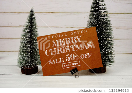 Festive display with small decorative Christmas trees with "Special Offer Merry Christmas Sale up to 50% off, Promotion Holiday Sale Event Festive display with small decorative Christmas trees with "Special Offer Merry Christmas Sale up to 50% off, Promotion Holiday Sale Event 133194913