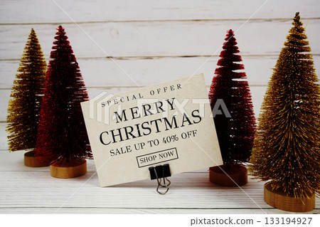 Festive display with small decorative Christmas trees with "Special Offer Merry Christmas Big Sale up to 40% off, Promotion Holiday Sale Event 133194927
