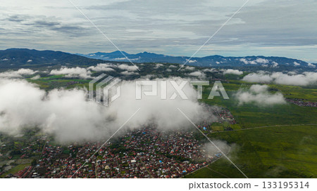 Valley with tea plantations and farmland with clouds. Kayu Aro, Sumatra, Indonesia. Tea estate landscape. Valley with tea plantations and farmland with clouds. Kayu Aro, Sumatra, Indonesia. Tea estate landscape. 133195314