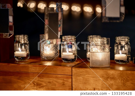 A relaxing space with glowing candles and glass decorations at night 133195428