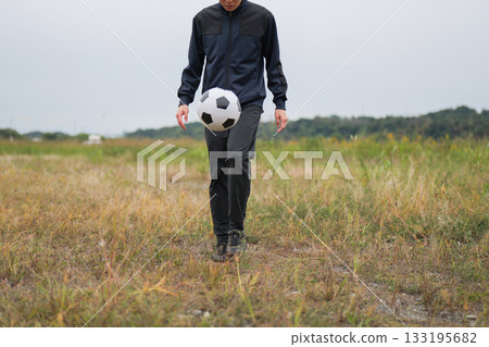 A man practicing soccer juggling 133195682