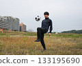 A man practicing soccer juggling 133195690