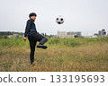 Man kicking a soccer ball 133195693