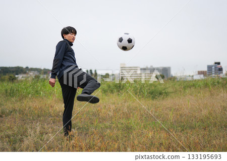Man kicking a soccer ball 133195693