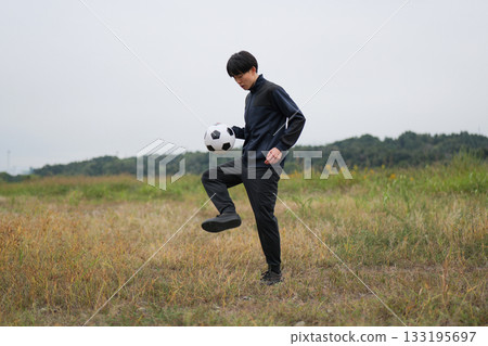 A man practicing soccer juggling 133195697