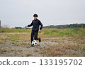 Smiling man chasing a soccer ball 133195702