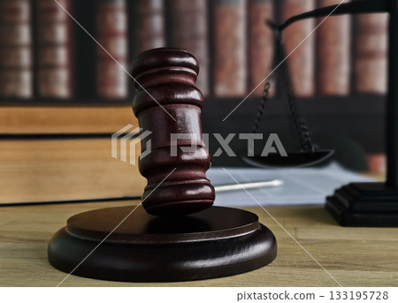 Justice is served with a gavel and scales of justice in a courtroom Justice is served with a gavel and scales of justice in a courtroom 133195728