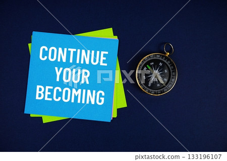 Continue Your Becoming text written on sticky note with compass on blue  background 133196107