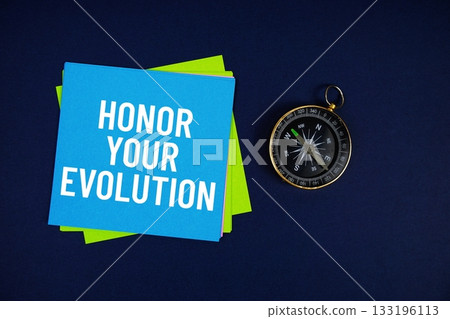 Honor Your Evolution text written on sticky note with compass on blue background Honor Your Evolution text written on sticky note with compass on blue background 133196113