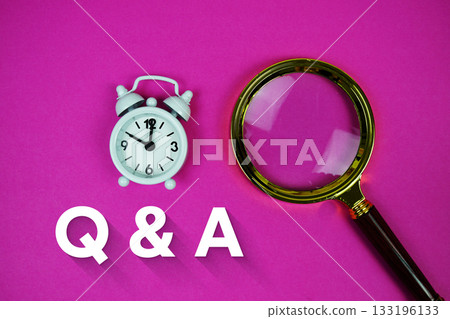 Alarm clock and a magnifying glass on a bright pink background, with text "Q & A" Alarm clock and a magnifying glass on a bright pink background, with text "Q & A" 133196133