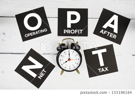 NOPAT Net Operating Profit After Tax with alarm clock on wooden background 133196184