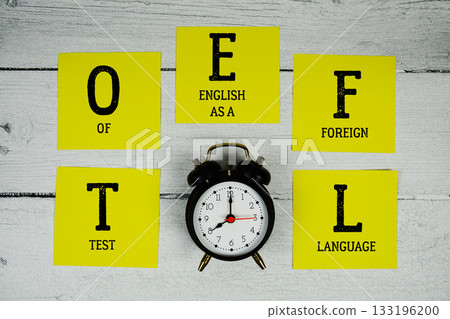 TOEFL Test of English as a Foreign Language with alarm clock on wooden background 133196200