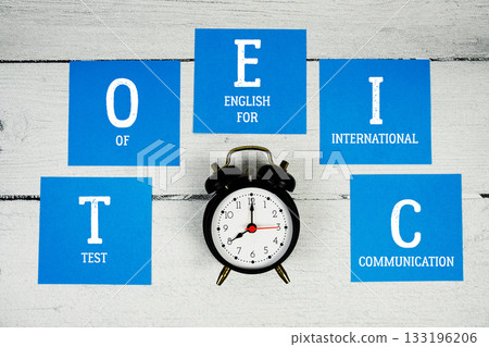 TOEIC Test of English for International Communication with alarm clock on wooden background TOEIC Test of English for International Communication with alarm clock on wooden background 133196206