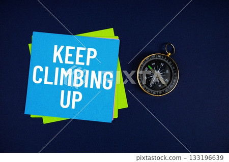 Keep Climbing Up text written on sticky note with compass on blue background Keep Climbing Up text written on sticky note with compass on blue background 133196639