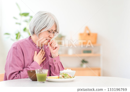 一位頭髮花白的老婦人因吸入性肺炎(吸入性肺炎,吞嚥困難)而窒息。 一位頭髮花白的老婦人因吸入性肺炎(吸入性肺炎,吞嚥困難)而窒息。 133196769
