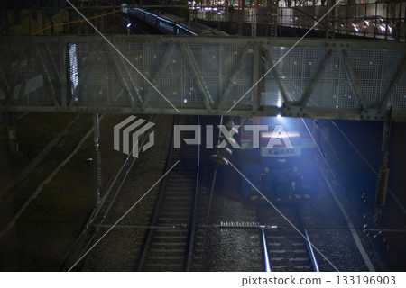Night view of a Korail train passing under a pedestrian bridge in Seoul, South Korea Night view of a Korail train passing under a pedestrian bridge in Seoul, South Korea 133196903