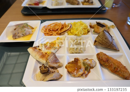 A segmented tray buffet plate that lets you enjoy the flavors of the world all at once 133197235