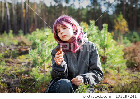 Girl with pink hair holding mushroom exploring forest Girl with pink hair holding mushroom exploring forest 133197241