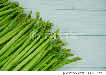 Bunch of fresh green asparagus stems on wooden background 133197290