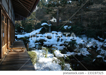 Snowy garden Winter trip to Kyoto - Winter light shining into a snow-covered Japanese garden viewed from the veranda of an old house 133197325