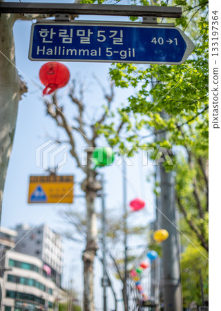 Street sign in a vibrant urban area with colorful lanterns in Seoul, South Korea 133197364