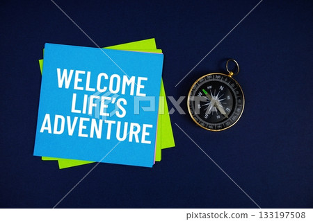 Welcome Life's Adventure text written on sticky note with compass on blue background 133197508