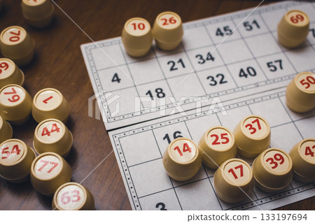 Playing lotto game. Cubes with figure on bingo card background. Nostalgia lifestyle. Table games. Retro games. Barrel with number and paper cards for bingo game. Holiday leisure. Luck concept.  133197694