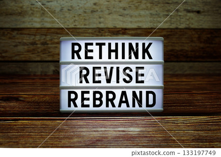 Lightbox with text "Rethink Revise Rebrand" on wooden background 133197749